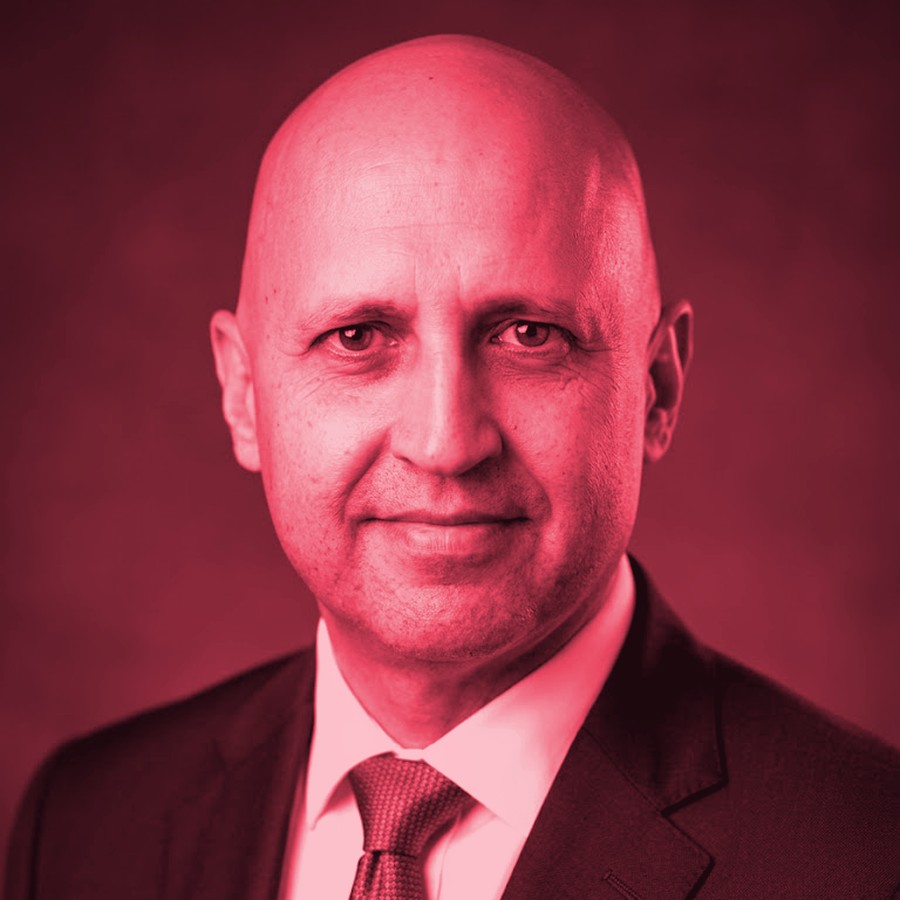 Professional portrait of Fabian de la Fuente in coral-red studio treatment.